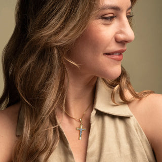 Woman wearing a 18k Gold Bicolor Crucifix Pendant against a neutral background