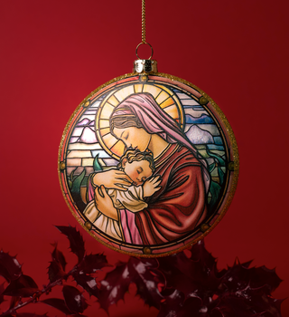 Decorative ornament with stained glass design of a woman holding a child on a red background