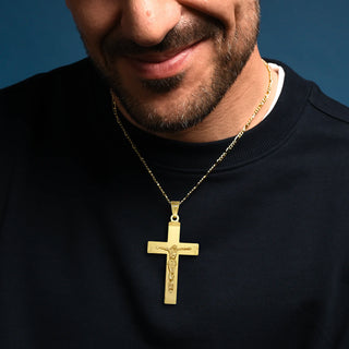 Man wearing a gLarge Golden Silver Crucifix Pendant against a blue background