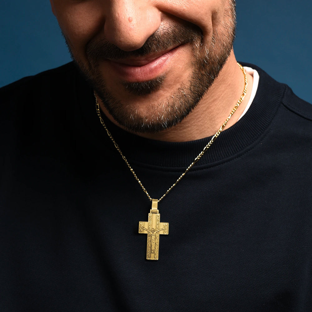 Man wearing a Golden Silver Crucifix Pendant with Intricate Engraving against a blue background