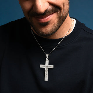Man wearing a Large Crucifix Pendant in Sterling Silver on a blue background