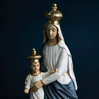 Statue of Our Lady of Victory in hand-painted resin holding the infant Jesus, both wearing gold crowns, set against a dark navy blue background. Statue of Our Lady of Victory in hand-painted resin