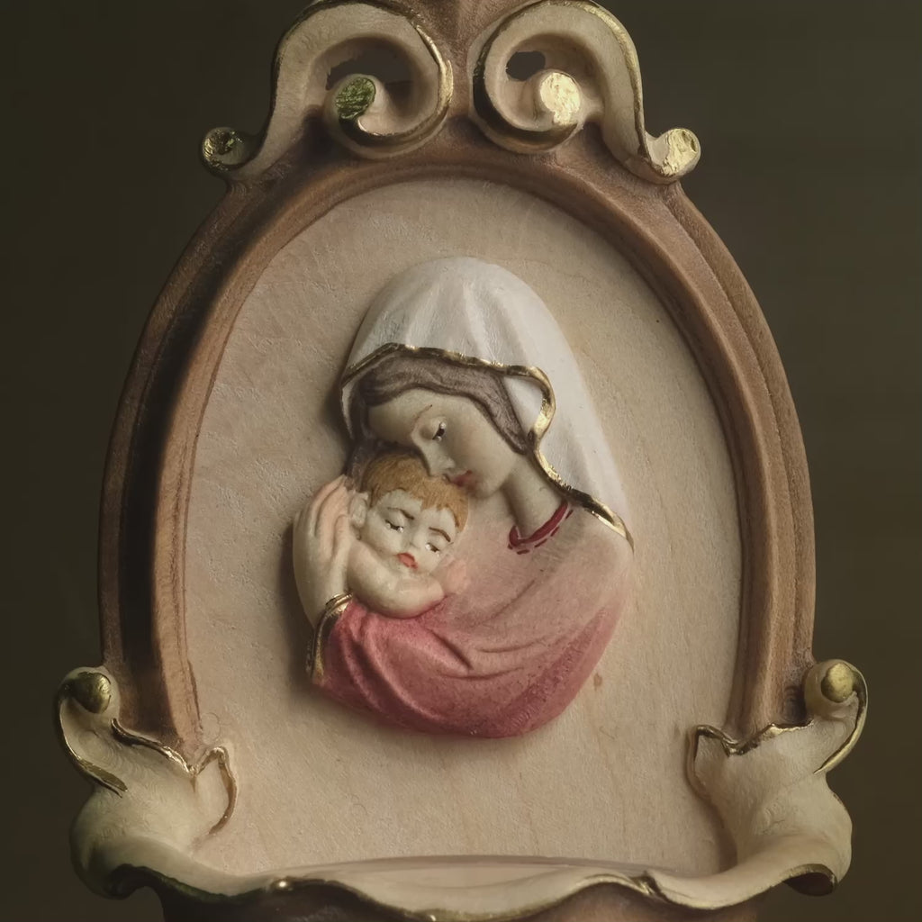 Detail of Madonna with Child holy water font for home in carved wood